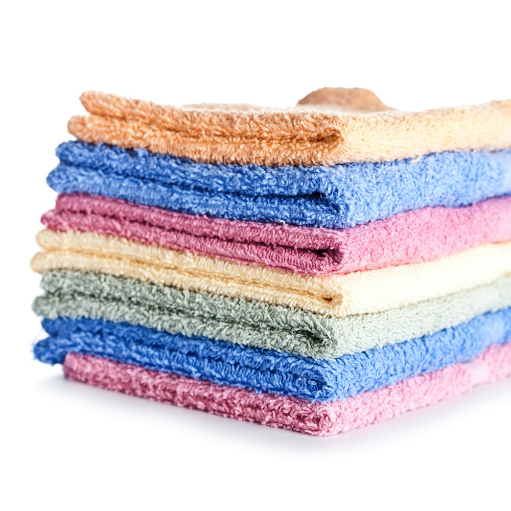 A stack of multicoloured cloths on a white background