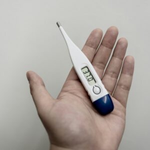 White and blue digital thermometer reading 36.9