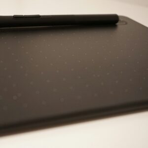 A pen resting on a black drawing tablet