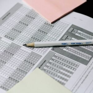A pencil resting on a multiple-choice answer sheet with pink sticky notes