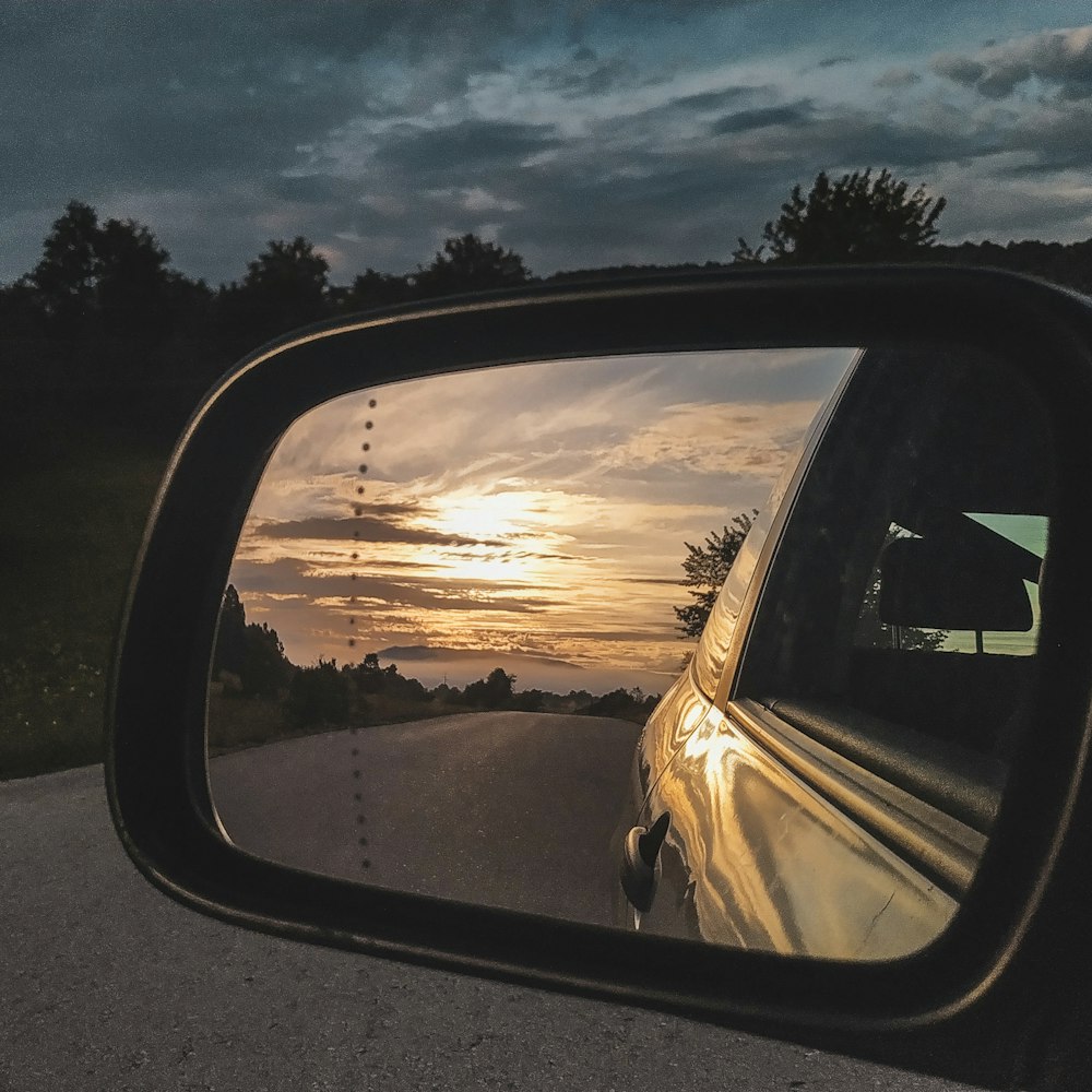 A car rear-view mirror reflecting a sunset