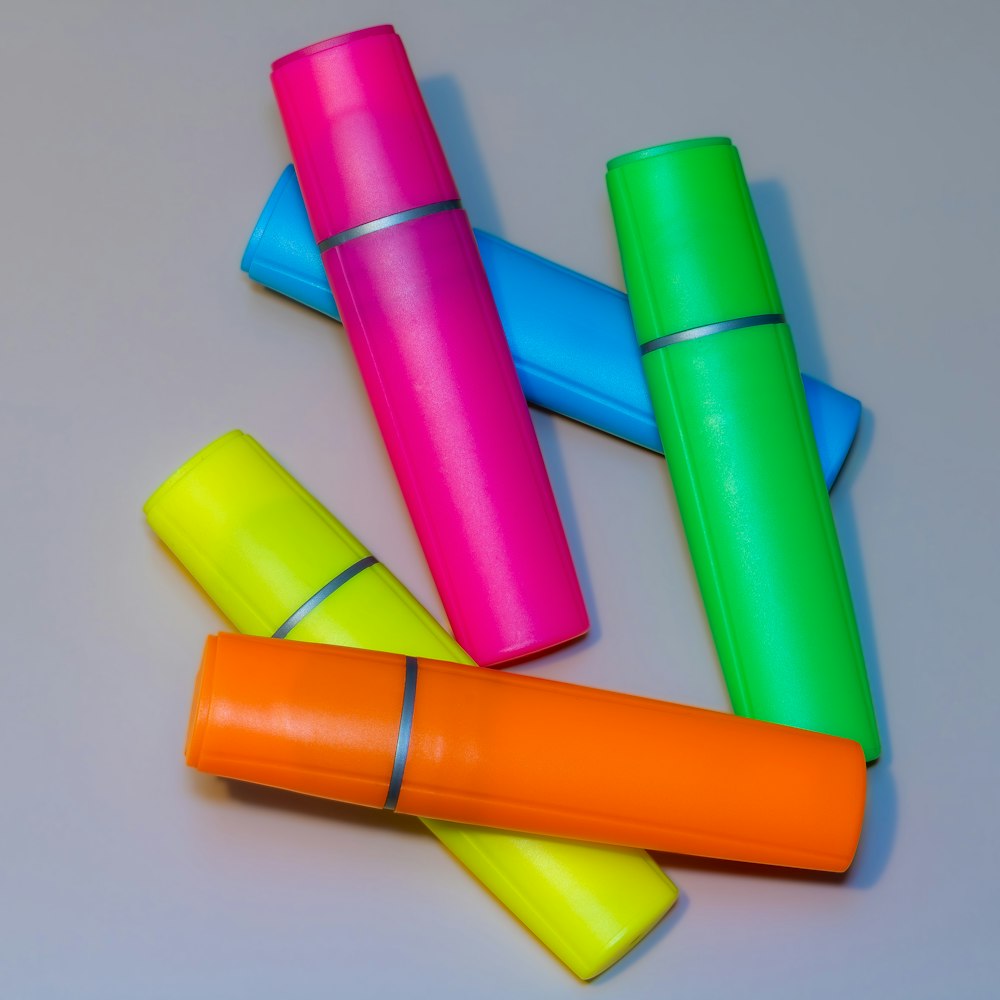 Several colourful highlighters scattered on a grey surface