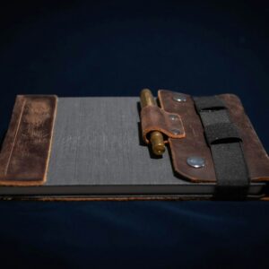 A rustic leather notebook with a pen on a dark background