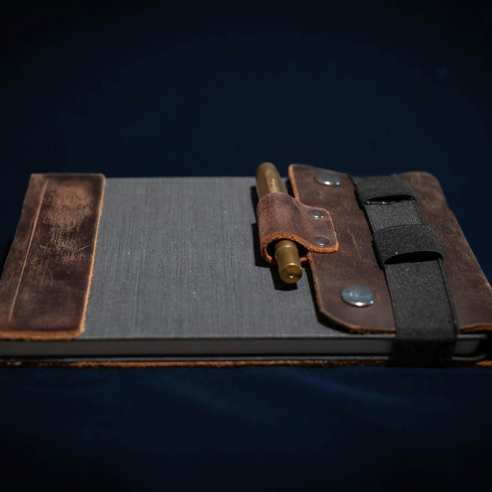 A rustic leather notebook with a pen on a dark background