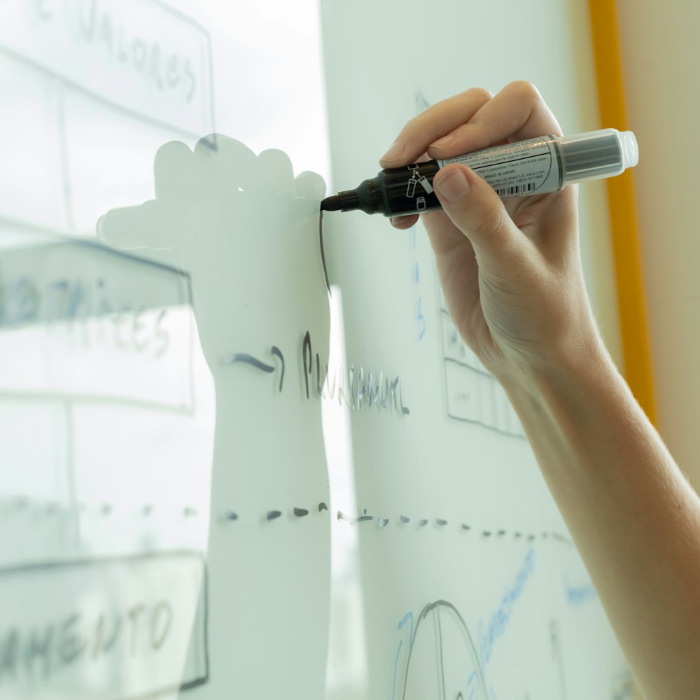 Hand drawing a diagram on a whiteboard