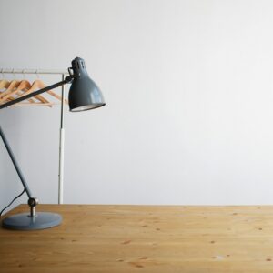 Grey balanced-arm lamp on a wooden table