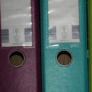 A row of coloured ring binders on a shelf