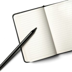 A notebook with a pencil on top