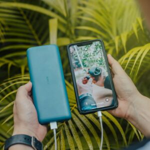 Green power bank next to a black smartphone