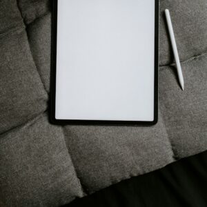 A white tablet computer on grey fabric