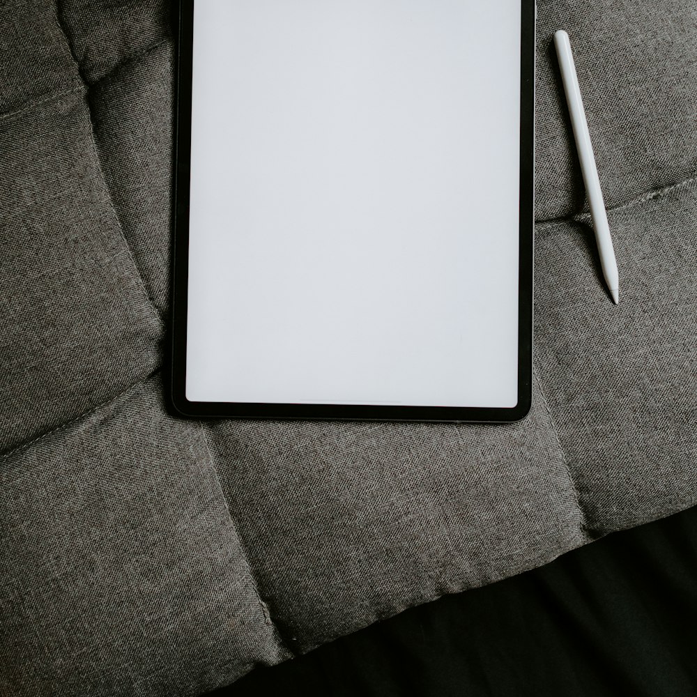 A white tablet computer on grey fabric